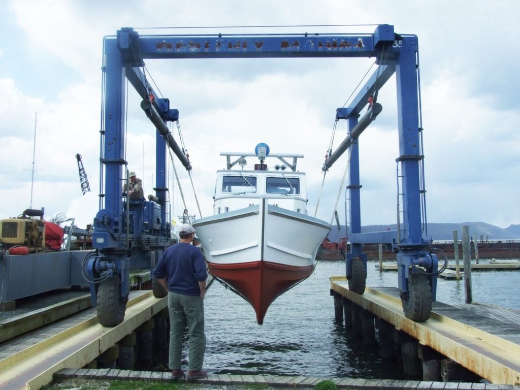 Captain John Lipscomb watches as the R. Ian Fletcher is lowered into the water after winter maintenance. 