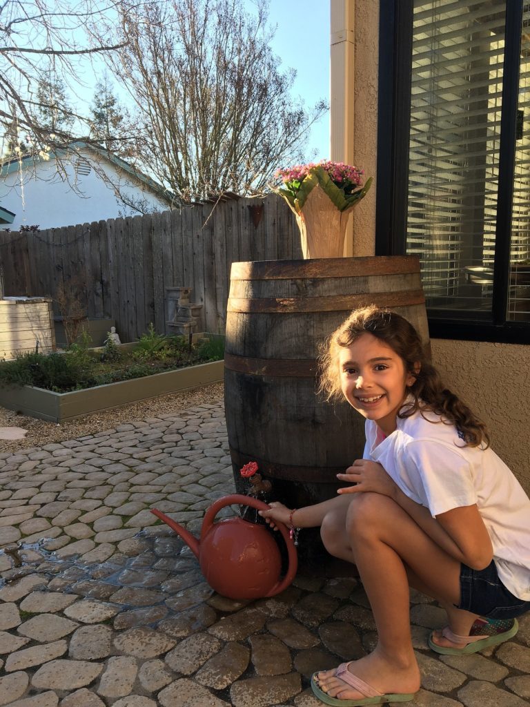 Little girl posing with a watering pot. 